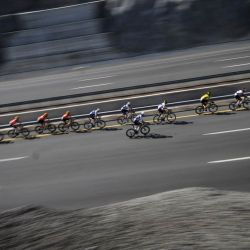 El grupo de ciclistas avanza durante la cuarta etapa de la carrera ciclista del Tour de Omán, desde el Museo Oman Across Ages hasta el Centro de Convenciones de Omán. | Foto:LOIC VENANCE / AFP