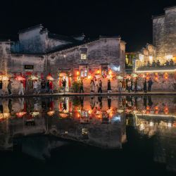 Imagen de un equipo de actuación de linternas con forma de pez desfilando, en la aldea de Hongcun, en la ciudad de Huangshan, en la provincia de Anhui, en el este de China. | Foto:Xinhua/Wang Cheng