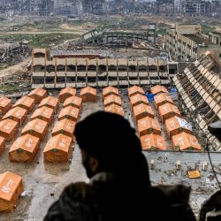 Un hombre de pie en lo alto de un edificio muy dañado observa las tiendas de campaña que albergan a palestinos desplazados, erigidas en el patio de una escuela secundaria en el norte de la ciudad de Gaza, en medio del actual acuerdo de alto el fuego en la guerra entre Israel y Hamás. | Foto:Bashar Taleb / AFP