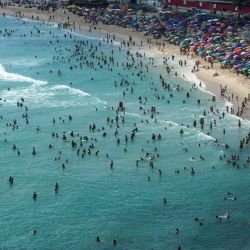 Vista aérea de personas disfrutando de la playa Recreio dos Bandeirantes en medio de una ola de calor en Río de Janeiro, Brasil. | Foto:TERCIO TEIXEIRA / AFP
