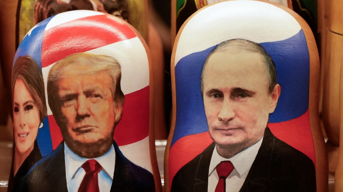 Traditional Russian wooden nesting dolls, Matryoshka dolls, depicting Russia's President Vladimir Putin (R), US President Donald Trump and his wife Melania Trump (L) are displayed for sale at a gift shop in downtown Moscow on February 13, 2025.