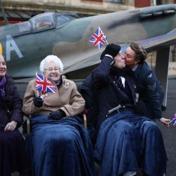 Doreen Simson, de 87 años, que fue evacuada de Londres durante su infancia, Wren Ruth Barnwell, de 100 años, el veterano Henry Rice, de 98 años, y la vocalista principal de D-Day Darlings, Katie Ashby, posan frente a una réplica de tamaño real de Spitfire durante una sesión fotográfica organizada por SSAFA, la organización benéfica de las Fuerzas Armadas más antigua del Reino Unido, para lanzar la cuenta regresiva de 80 días para el Día de la Victoria en Europa, afuera del Royal Albert Hall, en Londres. | Foto:HENRY NICHOLLS / AFP
