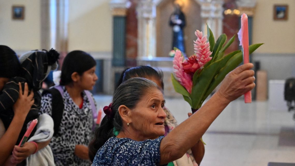 A Catholic parishioner lights a candle for the health of Pope Francis at the Basilica of Suyapa in Tegucigalpa on February 16, 2025.