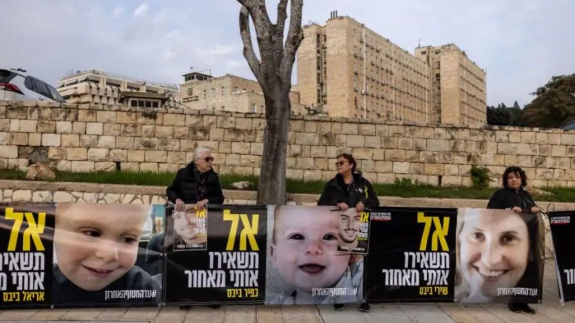 Israeli protest signs show hostages Ariel Bibas (L), Kfir Bibas (M) and Shiri Bibas (R).