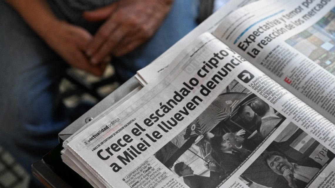 View of a newspaper front page featuring a picture of President Javier Milei and reading 'Crypto Scandal Grows, and Milei is Being Barraged by Complaints' in Buenos Aires on February 17, 2025. 