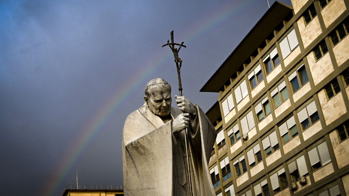 A rainbow appears above a statue of Pope John Paul II outside the Gemelli hospital where Pope Francis is hospitalised for tests and treatment for bronchitis in Rome, on February 18, 2025. 