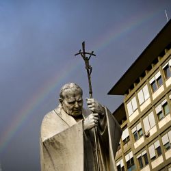 Un arcoíris aparece sobre una estatua del Papa Juan Pablo II en el exterior del hospital Gemelli, donde el Papa Francisco está internado para someterse a pruebas y recibir tratamiento por bronquitis en Roma. | Foto:Tiziana Fabi / AFP