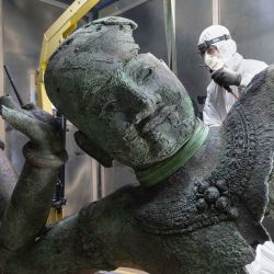 Un técnico trabaja en El Visnú reclinado del Mebon occidental, que se está restaurando en el Laboratorio Departamental Arc'Antique en Nantes, en el oeste de Francia, antes de su presentación en el Museo Guimet de París en abril de 2025. | Foto:Sebastien Salom-Gomis / AFP
