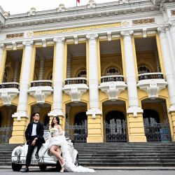 Una pareja posa para las fotografías de su boda frente a la Ópera de Hanoi, en Hanoi, Vietnam. | Foto:NHAC NGUYEN / AFP