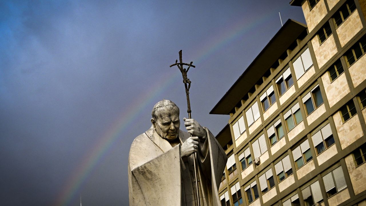 Un arcoíris aparece sobre una estatua del Papa Juan Pablo II en el exterior del hospital Gemelli, donde el Papa Francisco está internado para someterse a pruebas y recibir tratamiento por bronquitis en Roma. | Foto:Tiziana Fabi / AFP