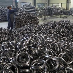 Un trabajador procesa anillos de acero inoxidable para bicicletas destinadas a la exportación en una fábrica de Hangzhou, en la provincia oriental china de Zhejiang. | Foto:AFP