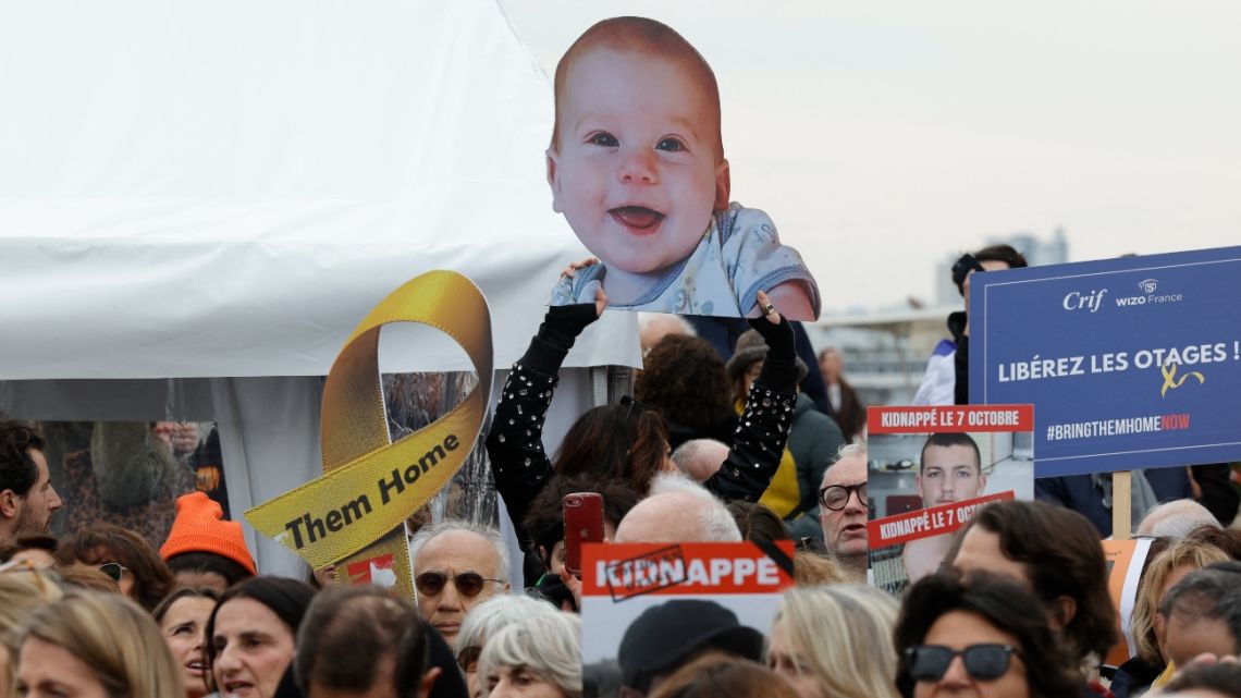 An attendee holds a portrait placard of Israeli hostage Kfir Bibas during a gathering in tribute to Israeli hostages, called by the Representative Council of French Jewish Institutions (CRIF) at the Trocadero square in Paris on February 21, 2025.