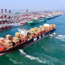  Una vista aérea muestra un buque portacontenedores guiado hasta su atracadero por remolcadores en el puerto de Qingdao. Foto de AFP | Foto:AFP