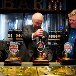 El rey Carlos III de Gran Bretaña sirve una pinta mientras habla con el propietario de la cervecería, John Mills. En el centro de Inglaterra. Foto de Jaimi Joy / AFP | Foto:AFP