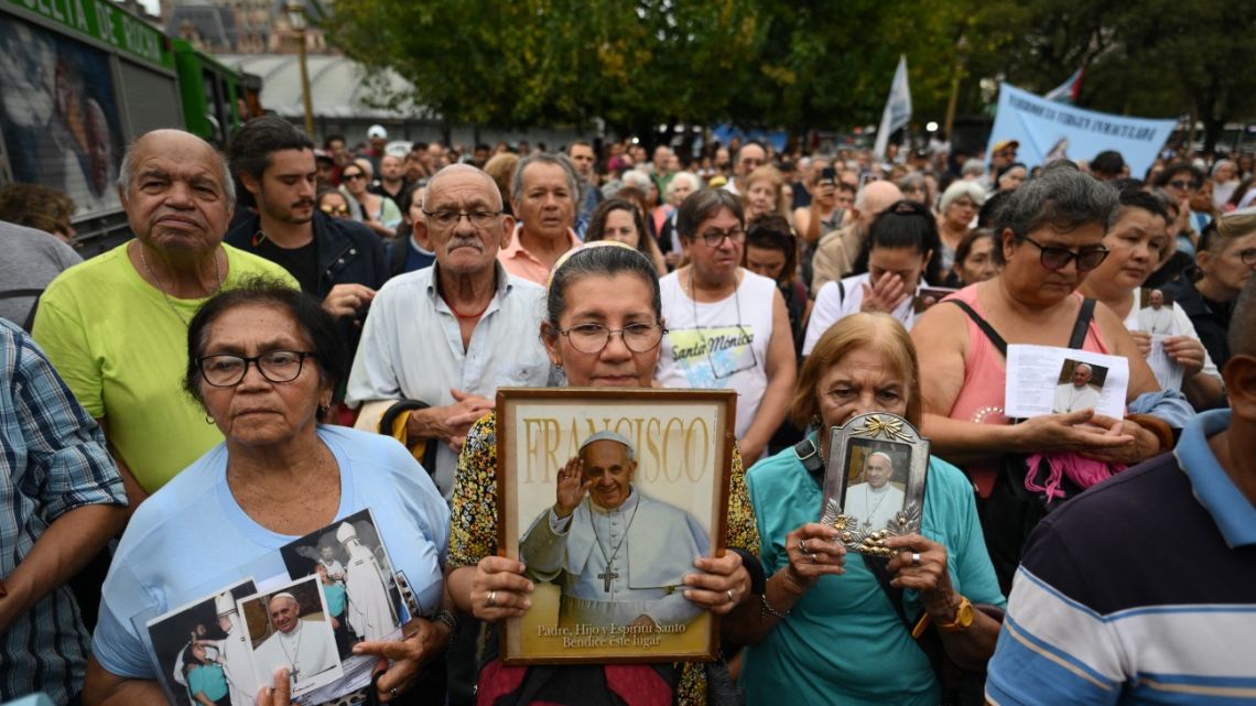 Faithful Catholics hold portraits of Pope Francis as they attend a mass for his healing in Constitution Square, the place where, when he was archbishop of Buenos Aires he gave annual masses to denounce exclusion and human trafficking in Buenos Aires, on February 24, 2025. Pope Francis, hospitalized due to bilateral pneumonia, remains in critical condition but is showing "slight improvement," the Vatican announced Monday night, as concern grows for the 88-year-old Argentine pontiff.