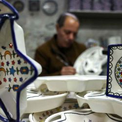 El palestino Loay Gheith decora platos de cerámica antes del mes sagrado islámico de ayuno del Ramadán en su fábrica de cerámica en la ciudad de Hebrón. Foto de HAZEM BADER / AFP | Foto:AFP