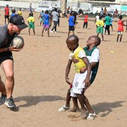 Daniel Andry técnico de la academia de rugby del Stade Toulousain de Francia, juega al rugby con niños durante un campamento en Abiyán. Foto de Issouf SANOGO / AFP | Foto:AFP