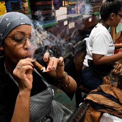 Una mujer fuma un puro en la fábrica de tabacos La Corona, durante la celebración del XXV Festival del Habano, en La Habana. Foto YAMIL LAGE / AFP | Foto:AFP