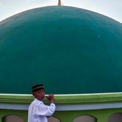 Un niño se ve junto a la cúpula de la mezquita mientras los oficiales del observatorio en la mezquita Al Mabrur en Surabaya. Foto de Juni KRISWANTO / AFP | Foto:AFP