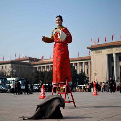 Un periodista, vestido con ropa de una minoría étnica, informa durante la sesión inaugural de la Asamblea Popular Nacional en la plaza de Tiananmen en Beijing. Foto de WANG Zhao / AFP | Foto:AFP