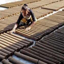 Una mujer prepara barras de estiércol de vaca, un sustituto de la madera, para secarlas al sol en un taller en la aldea de Bakrol. Foto de Sam PANTHAKY / AFP | Foto:AFP