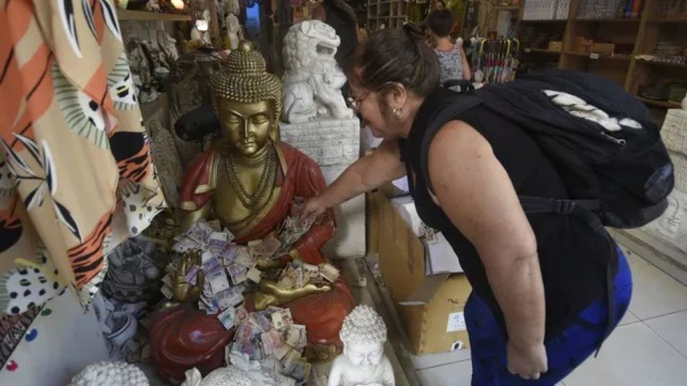 Una mujer deja sus billetes al buda en Rosario.