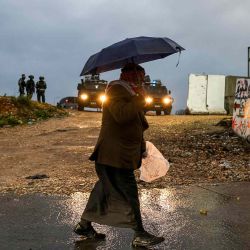 Un musulmán palestino camina bajo la lluvia para cruzar un puesto de control israelí en Qalandia. Foto de JAAFAR ASHTIYEH / AFP | Foto:AFP