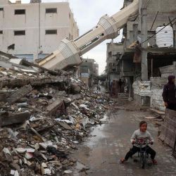 Un niño palestino monta en bicicleta cerca de un minarete caído de una mezquita destruida. Foto de Eyad BABA / AFP | Foto:AFP