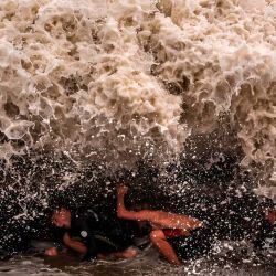 Unos jóvenes juegan en medio de olas que batieron récords provocadas por la franja exterior del ciclón tropical Alfred en Point Danger, en Coolangatta. Foto de DAVID GRAY / AFP | Foto:AFP