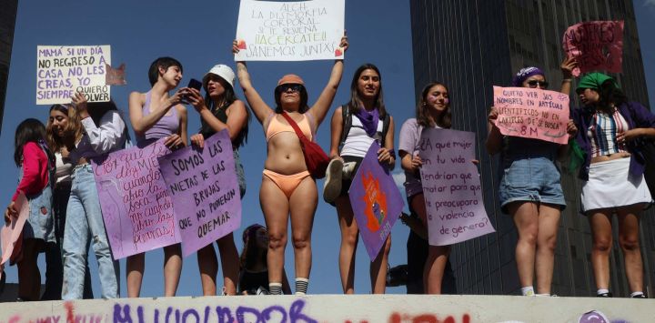 Manifestantes sostienen carteles durante una manifestación por el Día Internacional de la Mujer en la Ciudad de México.