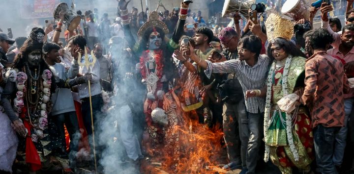 Una devota baila frente a una pira funeraria en llamas mientras participa en el 'Masaan' o 'Bhasma' Holi, celebrado con cenizas de la pira, a lo largo de las orillas del río Ganges en Harishchandra Ghat en Varanasi, India.