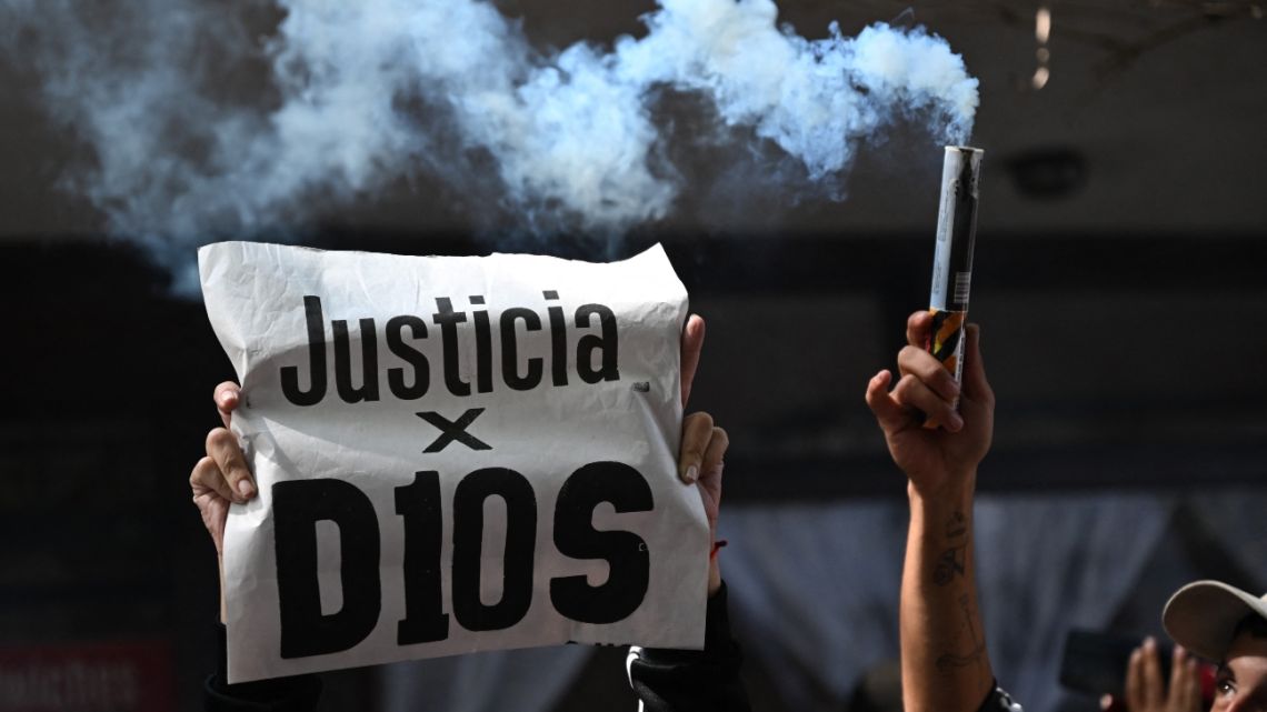 A fan holds a banner that reads in Spanish 'Justice for D10s' as he waits outside the San Isidro court during the trial for the death of late Argentine football legend Diego Maradona in Buenos Aires province, Argentina on March 11, 2025.