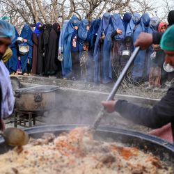 Mujeres afganas vestidas con burka hacen fila para recibir comida iftar gratuita durante el Ramadán, el mes sagrado islámico de ayuno, en las afueras de Kabul. | Foto:WAKIL KOHSAR / AFP
