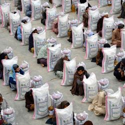 Afganos reciben sacos de comida donados por una organización benéfica durante el Ramadán, el mes sagrado islámico de ayuno, en Kandahar. | Foto:Sanaullah Seiam / AFP