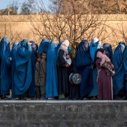 Mujeres afganas vestidas con burka hacen fila para recibir comida iftar gratuita durante el Ramadán, el mes sagrado islámico de ayuno, en las afueras de Kabul. | Foto:WAKIL KOHSAR / AFP