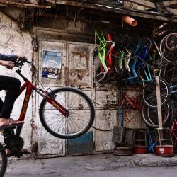 Un niño anda en bicicleta en el campamento de Al-Amari, al sur de Ramallah, en la Cisjordania ocupada. | Foto:ZAIN JAAFAR / AFP