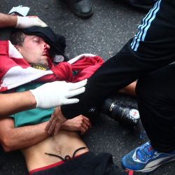 Argentine photojournalist Pablo Grillo receives medical treatment by paramedics after being injured during a protest of pensioners supported by football fans against the government of President Javier Milei in Buenos Aires on March 12, 2025.