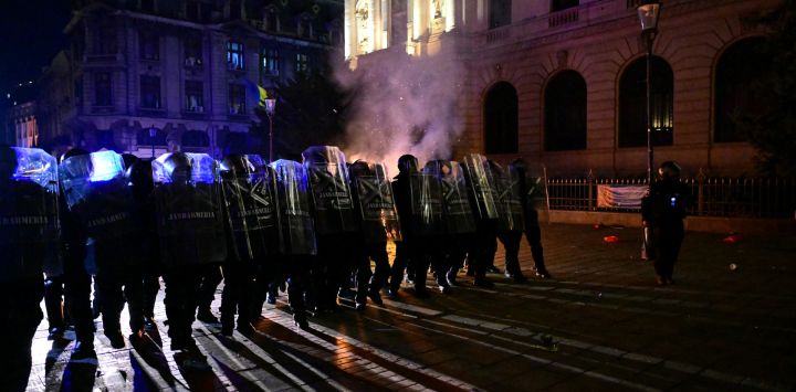 Gendarmes rumanos con equipo antidisturbios se enfrentan a manifestantes en medio de enfrentamientos durante una manifestación cerca de la Oficina Electoral Central en Bucarest, después de que la oficina electoral rechazara la candidatura de Georgescu para la repetición de las elecciones presidenciales anuladas del año pasado.