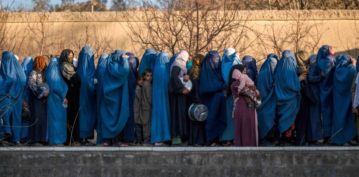 Mujeres afganas vestidas con burka hacen fila para recibir comida iftar gratuita durante el Ramadán, el mes sagrado islámico de ayuno, en las afueras de Kabul.