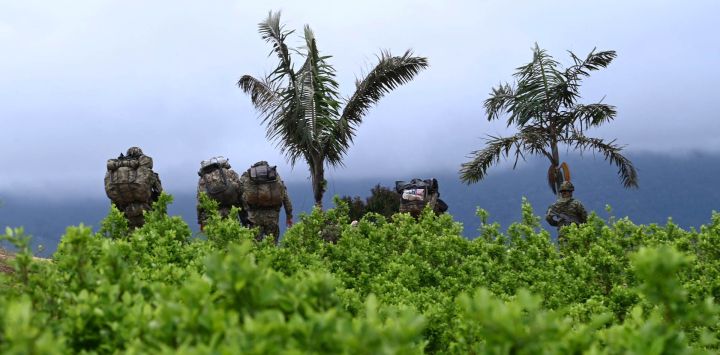 Soldados se alejan entre plantaciones de coca después de que las comunidades locales los obligaran a abandonar su base militar cerca de El Plateado, departamento del Cauca, Colombia.