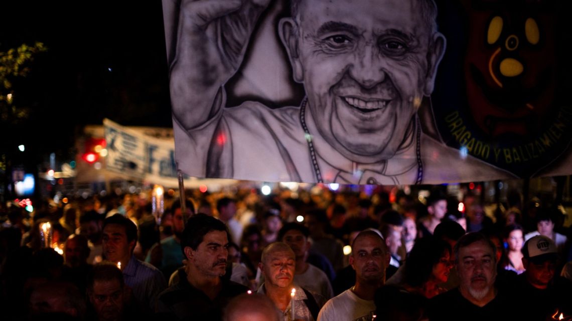 People hold up an image of Pope Francis during a vigil to pray for his health in Buenos Aires on March 7, 2025. 