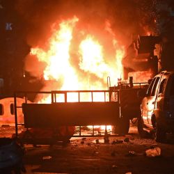 Un bombero se encuentra cerca de los vehículos incendiados tras los enfrentamientos en la zona de Chitnavis Park Square, en Nagpur, India. | Foto:AFP