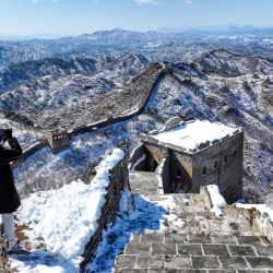 Imagen tomada con un dron de un turista fotografiando el paisaje nevado en la sección de Jinshanling de la Gran Muralla cubierta por nieve, en el distrito de Luanping de Chengde, en la provincia de Hebei, en el norte de China. | Foto:Xinhua/Chen Yehua