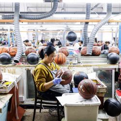 Los empleados producen pelotas de baloncesto que se exportarán a Europa en una fábrica en Sihong. Foto de AFP | Foto:AFP