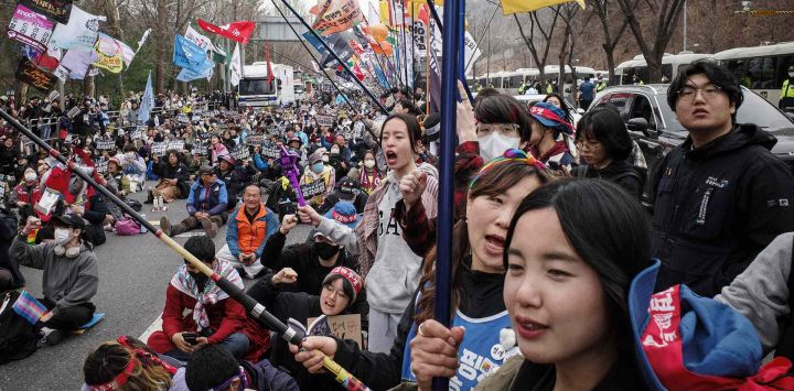 Miembros de la Liga Campesina de Corea, sostienen banderas durante una protesta contra el presidente de Corea del Sur, Yoon Suk Yeol, destituido, en Seúl. Foto de ANTHONY WALLACE / AFP