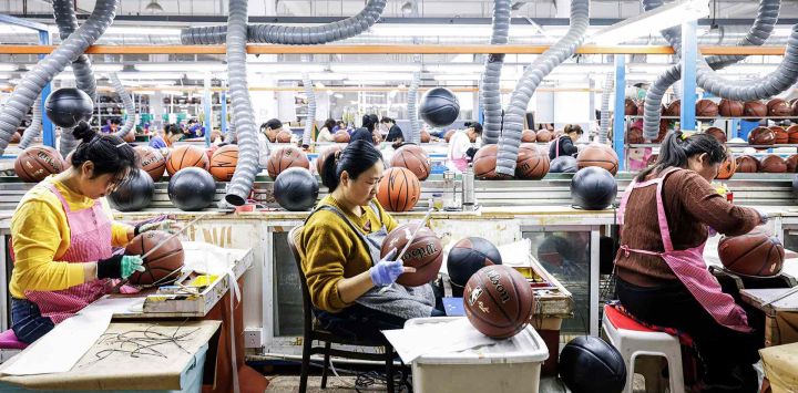 Los empleados producen pelotas de baloncesto que se exportarán a Europa en una fábrica en Sihong. Foto de AFP