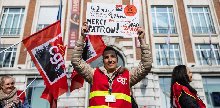 Un trabajador de Société Générale lleva un chaleco de la CGT y una pancarta durante una manifestación frente a una sucursal de SG Credit du Nord. Foto de Sameer Al-DOUMY / AFP