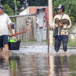 Personas caminan por una calle inundada tras el desbordamiento del río Cotoca en Puerto Pailas, departamento de Santa Cruz, Bolivia. Foto de RODRIGO URZAGASTI / AFP | Foto:AFP