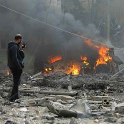 Un hombre toma fotos con su teléfono móvil en el lugar de un ataque israelí en el sur de Beirut. Foto de AFP | Foto:AFP