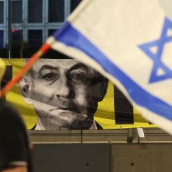 Un manifestante ondea la bandera israelí durante una protesta antigubernamental que exige la liberación de los rehenes israelíes cautivos desde los ataques del 7 de octubre perpetrados por militantes palestinos en la Franja de Gaza. | Foto:JACK GUEZ / AFP